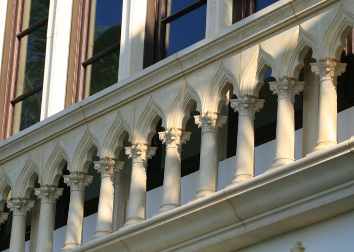 Gothic-style cast stone balustrade with pointed arch colonettes and carved Corinthian capitals