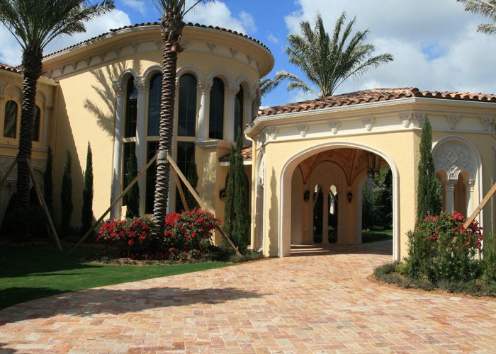 Mediterranean luxury estate with cast stone arched porte-cochère and ornate window surrounds