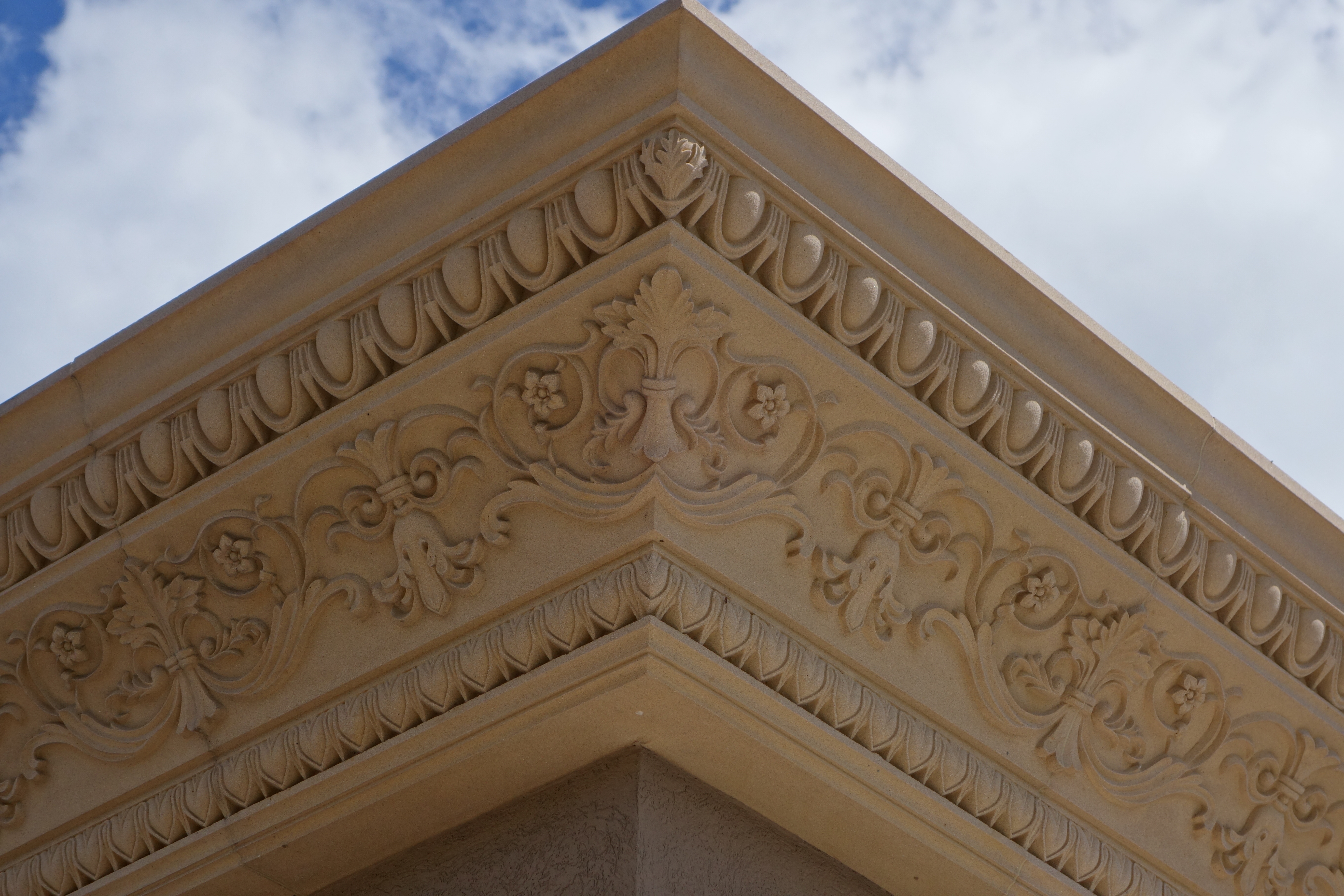 Intricately carved cast stone cornice and entablature corner detail